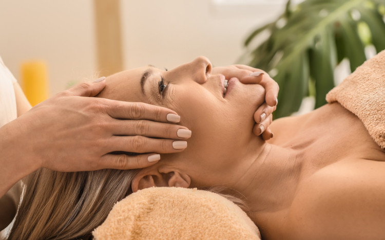 uśmiechnięta kobieta na masażu liftingującym twarz