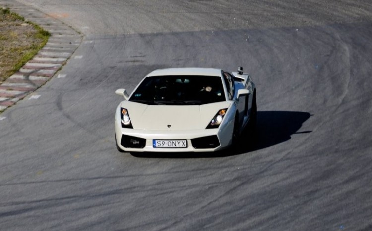 Białe Lamborghini na trasie toru wyścigowego