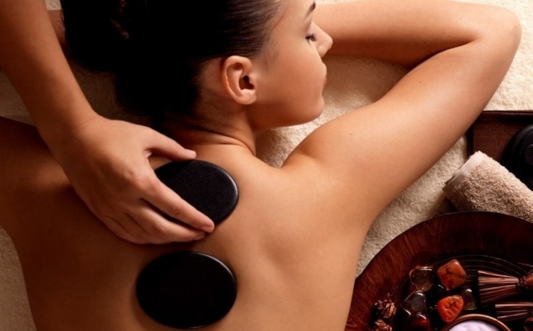 kobieta na masażu pleców gorącymi kamieniami