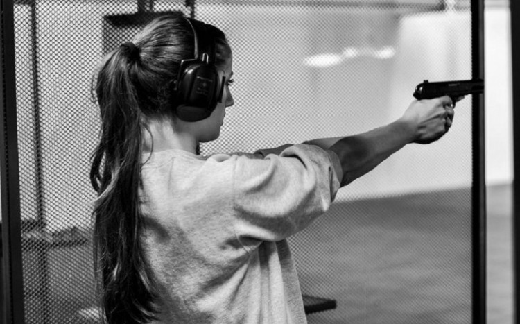 Kobieta podczas strzelania z broni krótkiej
