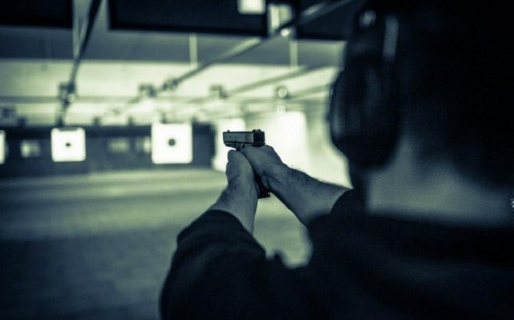 Kobieta oddaje strzał z krótkiej broni