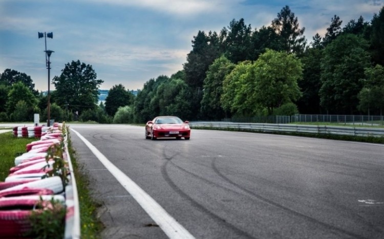 Czerwone Ferrari F430 podczas jazdy na torze