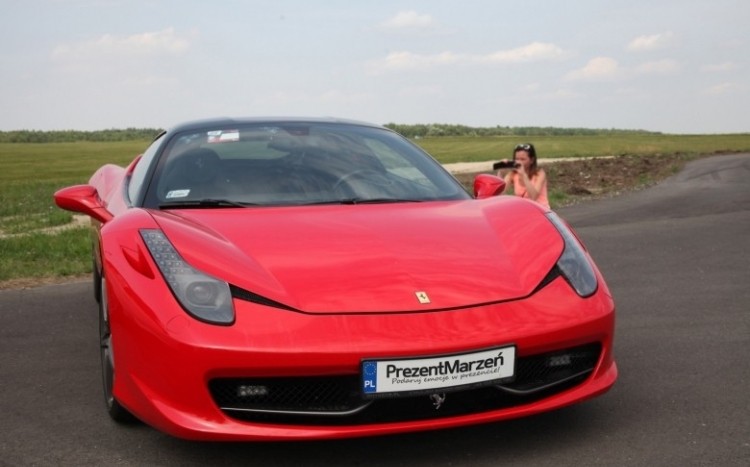 Kobieta fotografująca stojące Ferrari Italia