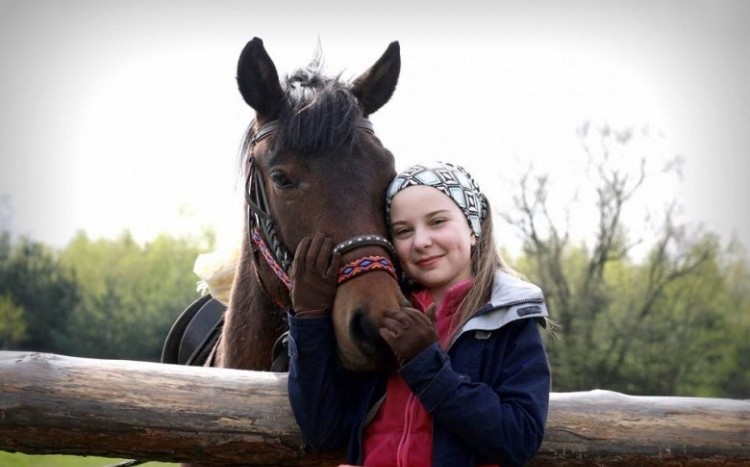 Dziewczynka stojąca naprzeciwko konia