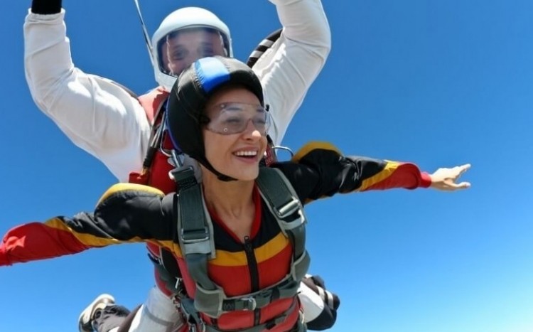 kobieta oddaje skok ze spadochronem w tandemie