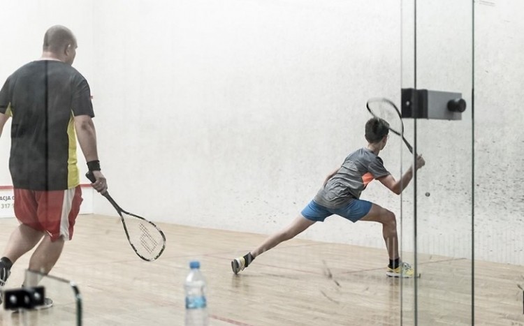 Gra w squasha - widok przez szklaną ścianę