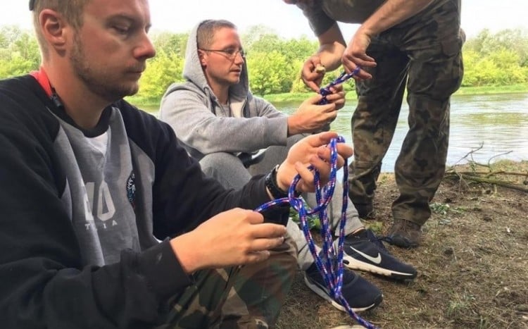 Trzech mężczyzn uczy się wiązać węzły