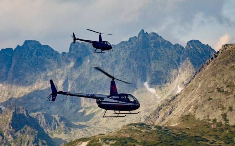 Dwa helikoptery na tle gór