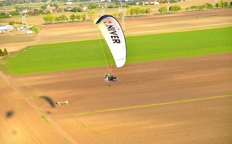 Motoparalotnia podczas lotu na tle pól uprawnych