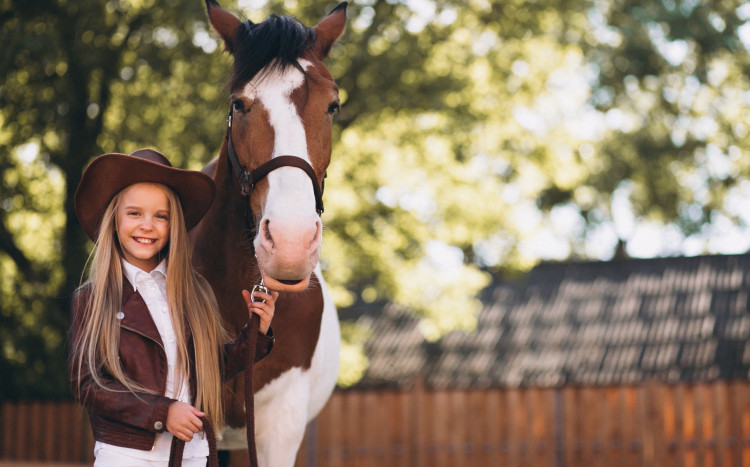 mała dziewczynka pozująca z koniem