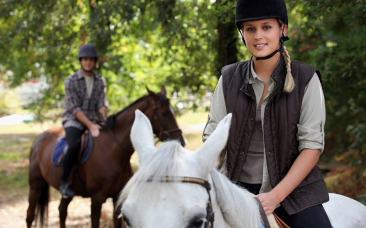 młoda kobieta ćwiczy jazdę konną na ujeżdżalni