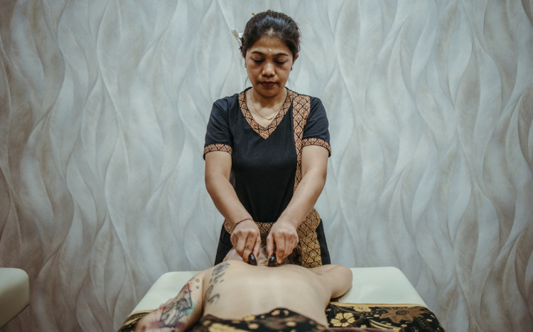 Kobieta wykonuje masaż kamieniami