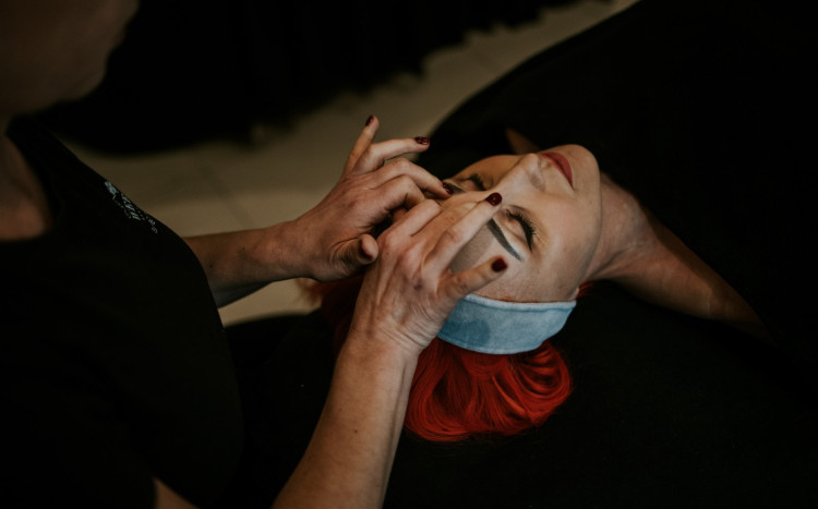 Odprężona kobieta podczas masażu twarzy