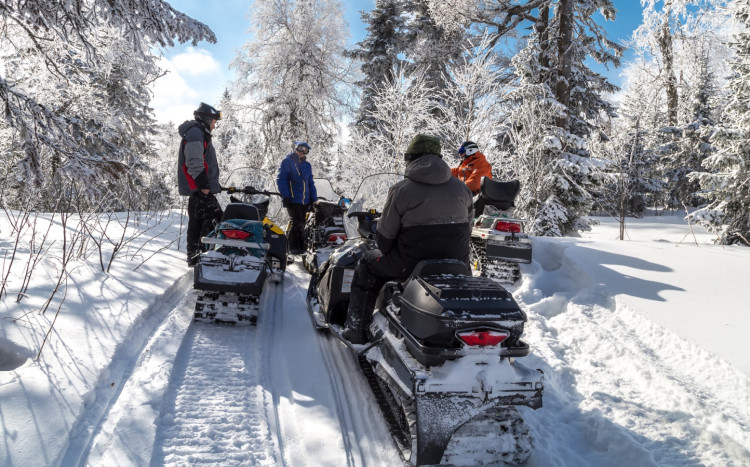 grupa osób na skuterach śnieżnych