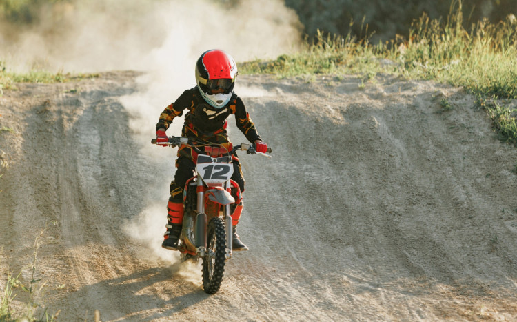 chłopiec zjeżdża z górki motocrossem