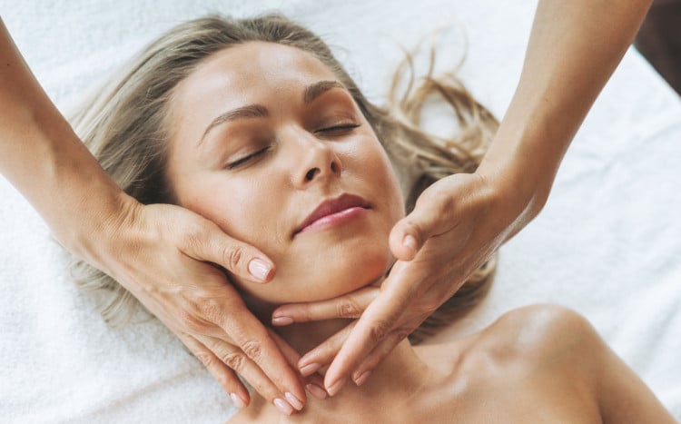młoda kobieta relaksuje się w czasie masażu twarzy