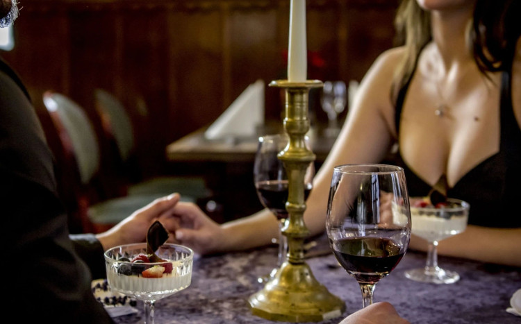 kobieta z mężczyzną na kolację we dwoje, kieliszki z winem na stole