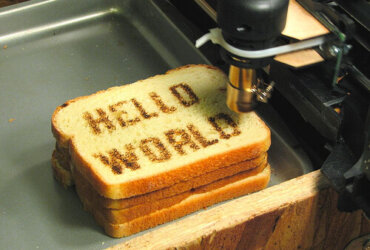 Napis HelloWorld wypalony na kromce chleba