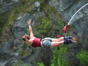 Kobieta podczas skoku na bungee z rozłożonymi rękoma