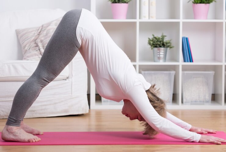kobieta w średnim wieku ćwiczy jogę w domu