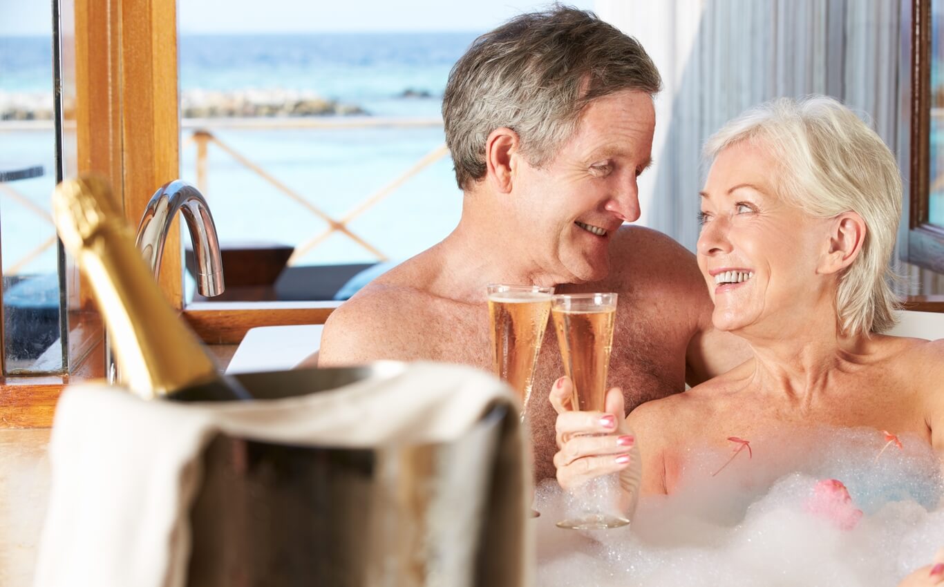 małżeństwo w średnim wieku relaksuje się w jacuzzi z lampką szampana