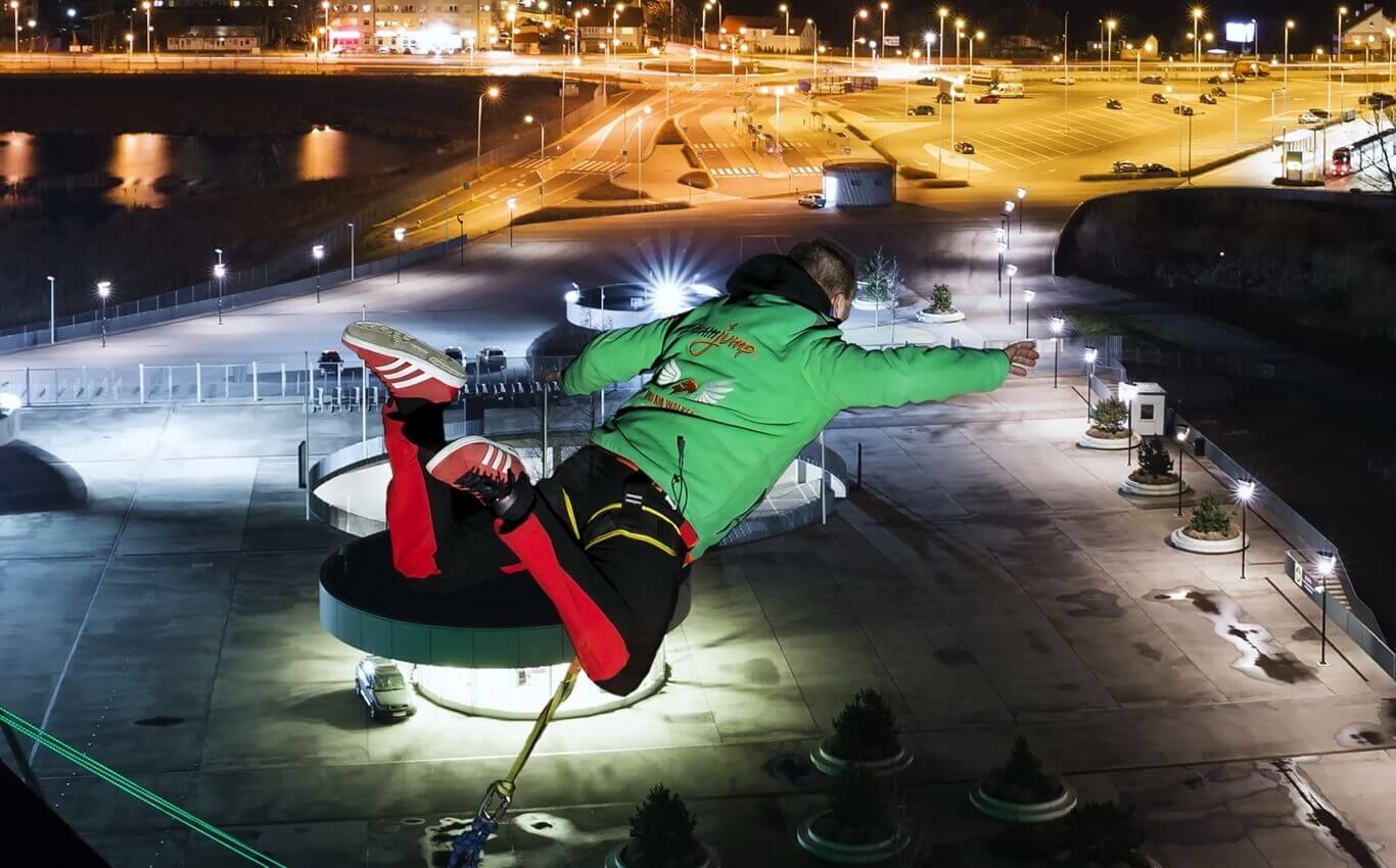 młody mężczyzna oddaje skok dream jump nocą