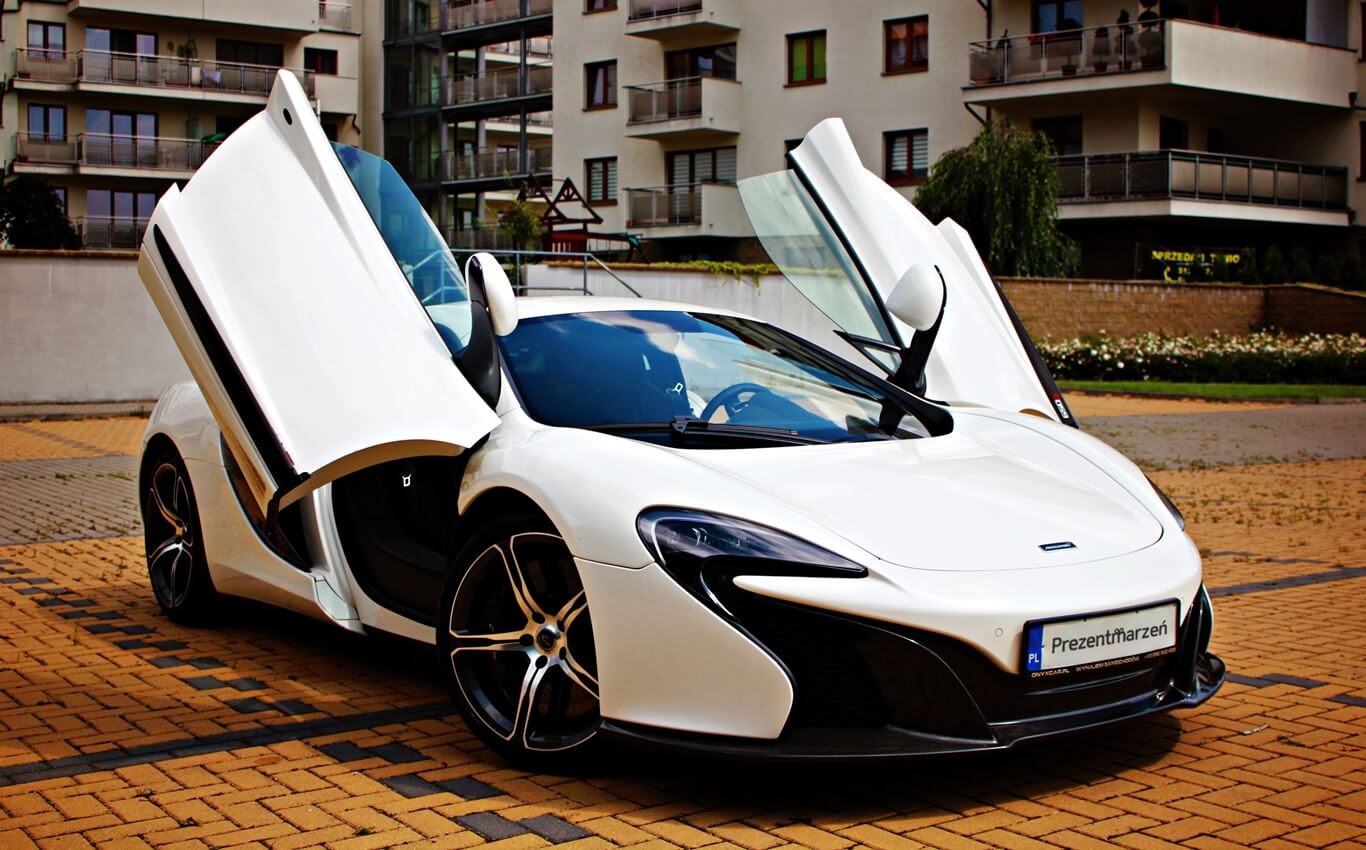 biały mclaren 650s z otwartymi drzwiami widok z boku