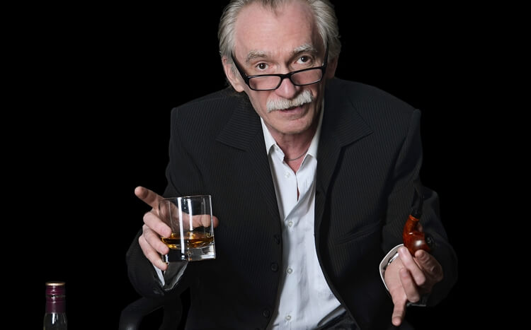 starszy mężczyzna ze szklaną whisky i fajką
