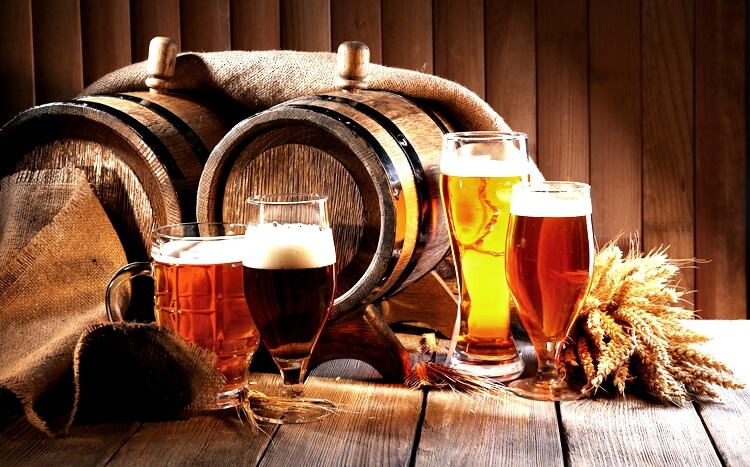 różne gatunki piwa na tle drewnianej beczki