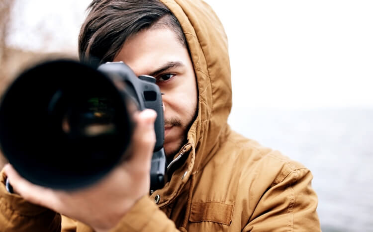 przystojny młody mężczyzna z aparatem fotograficznym