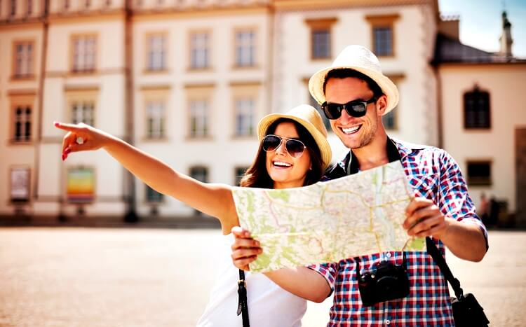 uśmiechnięta para zwiedza miasto z mapą