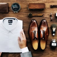 męska koszula, buty, pasek, zegarek i pędzel do golenia na drewnianym tle