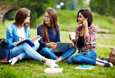 trzy koleżanki uczą się w parku