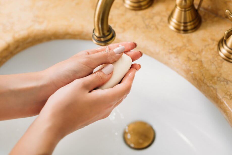 kobieta myje ręce by uniknąć zakażenia koronawirusem
