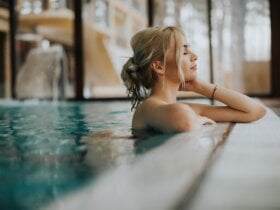 Młoda kobieta o blond włosach relaksuje się w basenie SPA