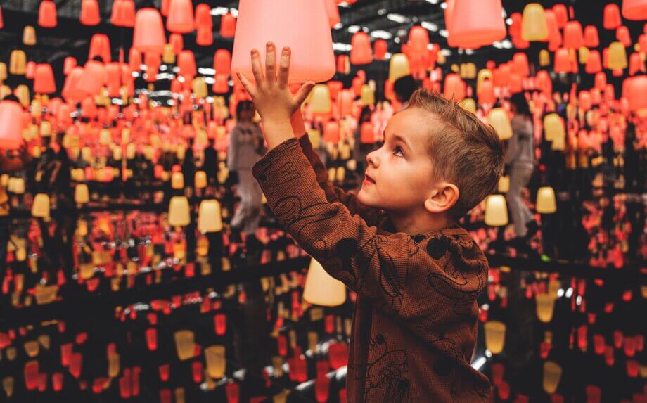 Chłopczyk dotykający wiszącą lampę w Funzeum