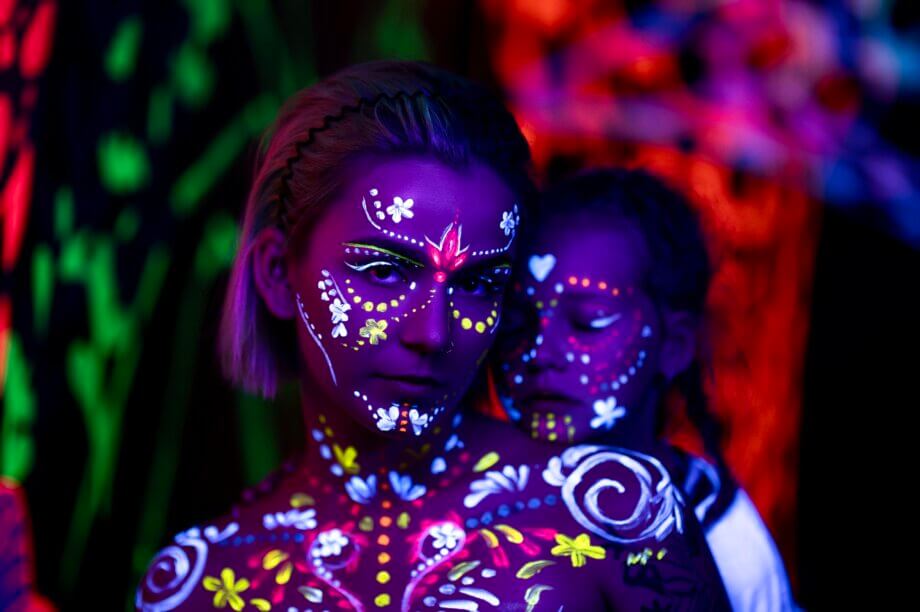 Kobieta i dziecko pomalowane na twarzy farbami fluorescencyjnymi