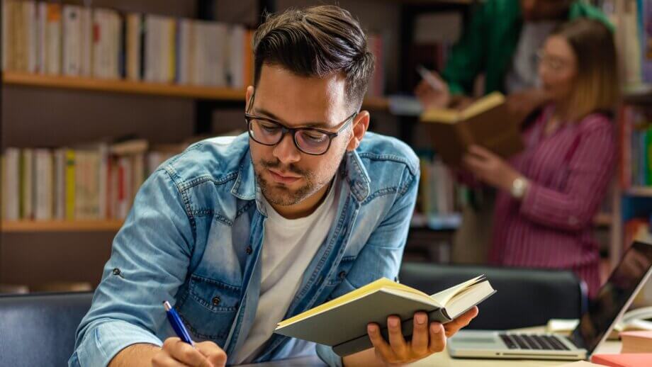 mężczyzna z książką w bibliotece