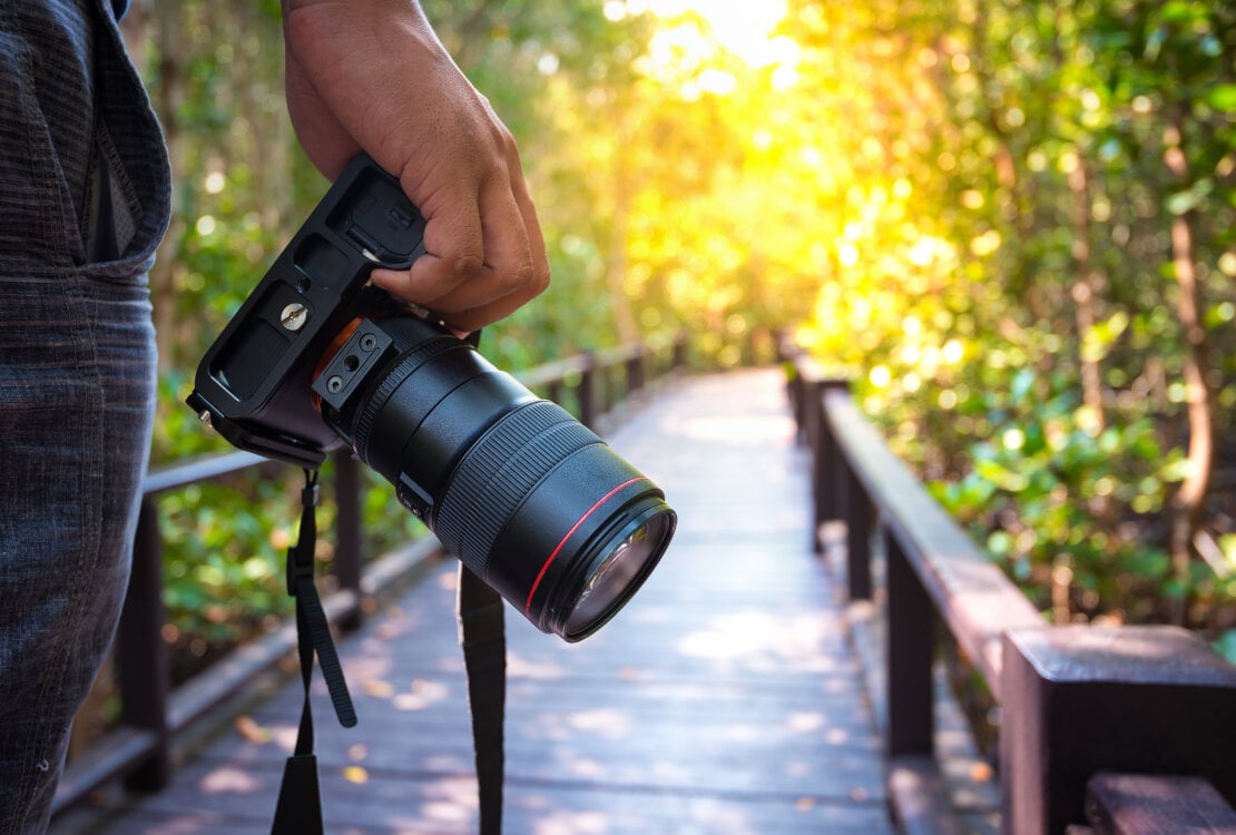 człowiek trzymający aparat fotograficzny