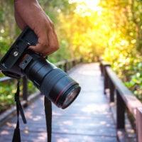 człowiek trzymający aparat fotograficzny