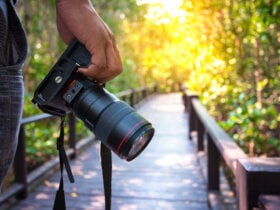 człowiek trzymający aparat fotograficzny