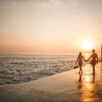 Para zakochanych spacerująca nad brzegiem morza