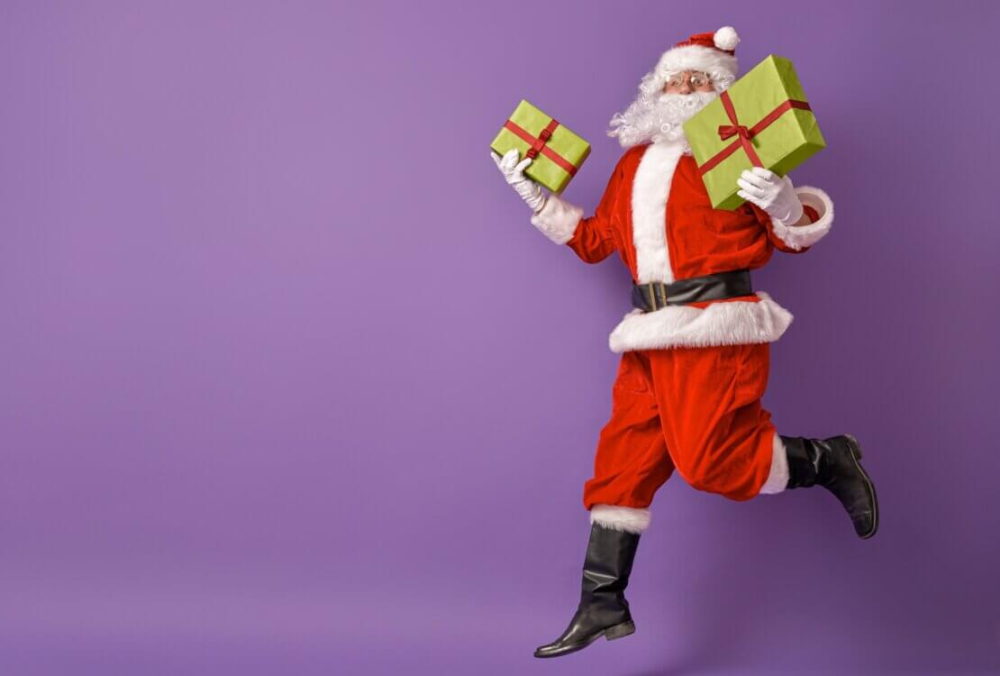 Święty Mikołaj z prezentami na fioletowym tle