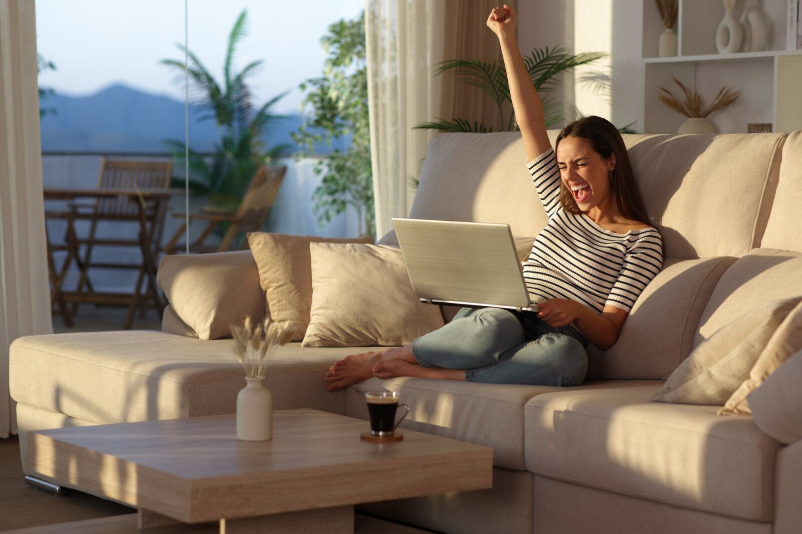 Ucieszona kobieta patrząca w ekran laptopa