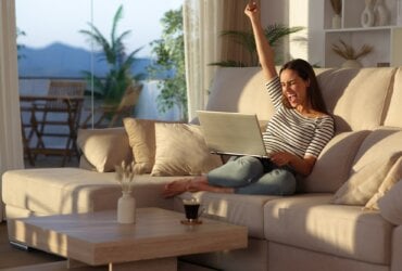 Ucieszona kobieta patrząca w ekran laptopa