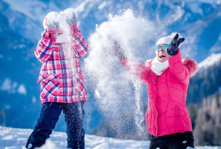 Rodzina podczas zimy bawiąca się śniegiem