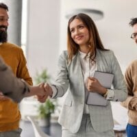 Szefowa ściskająca dłoń swojej pracownicy