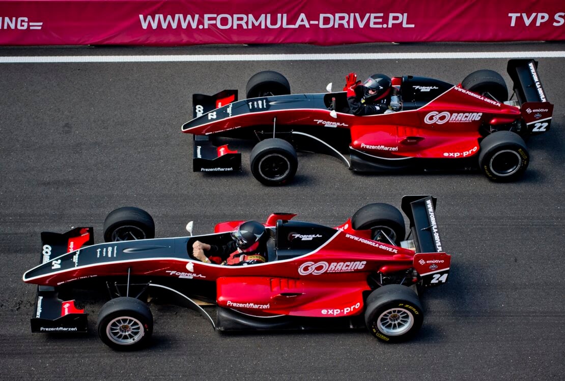 Dwa czerwone bolidy F1 na torze wyścigowym
