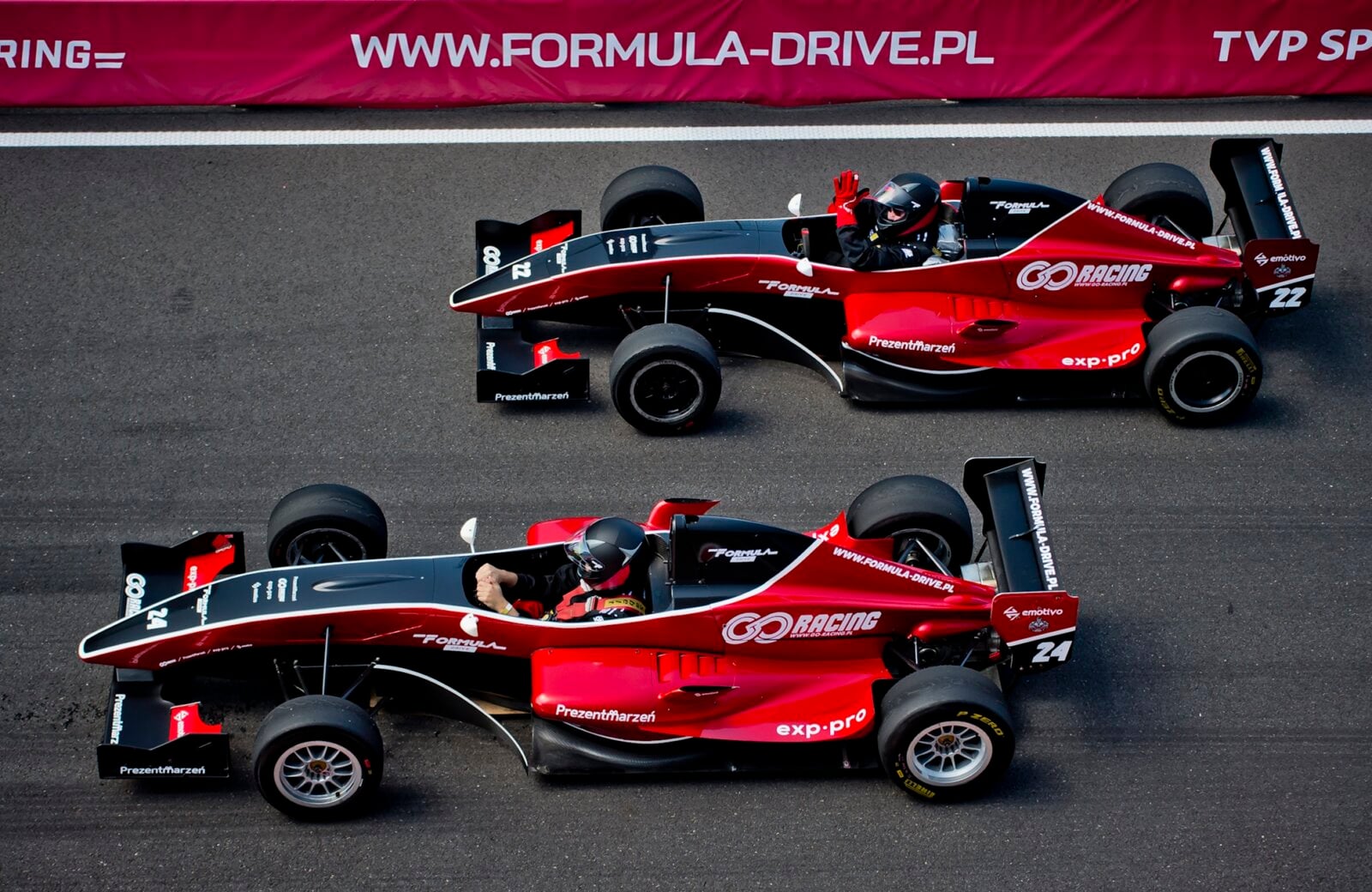 Dwa czerwone bolidy F1 na torze wyścigowym