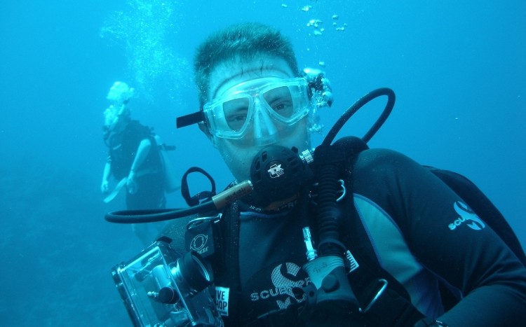 mężczyzna w stroju płetwonurka pod wodą